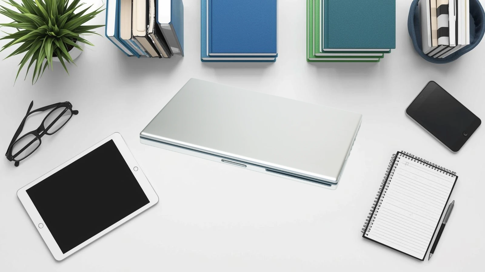 Top-down photography view of a perfectly organized white desk with neatly stacked blue and green textbooks, a tablet, and stationery, representing structured learning